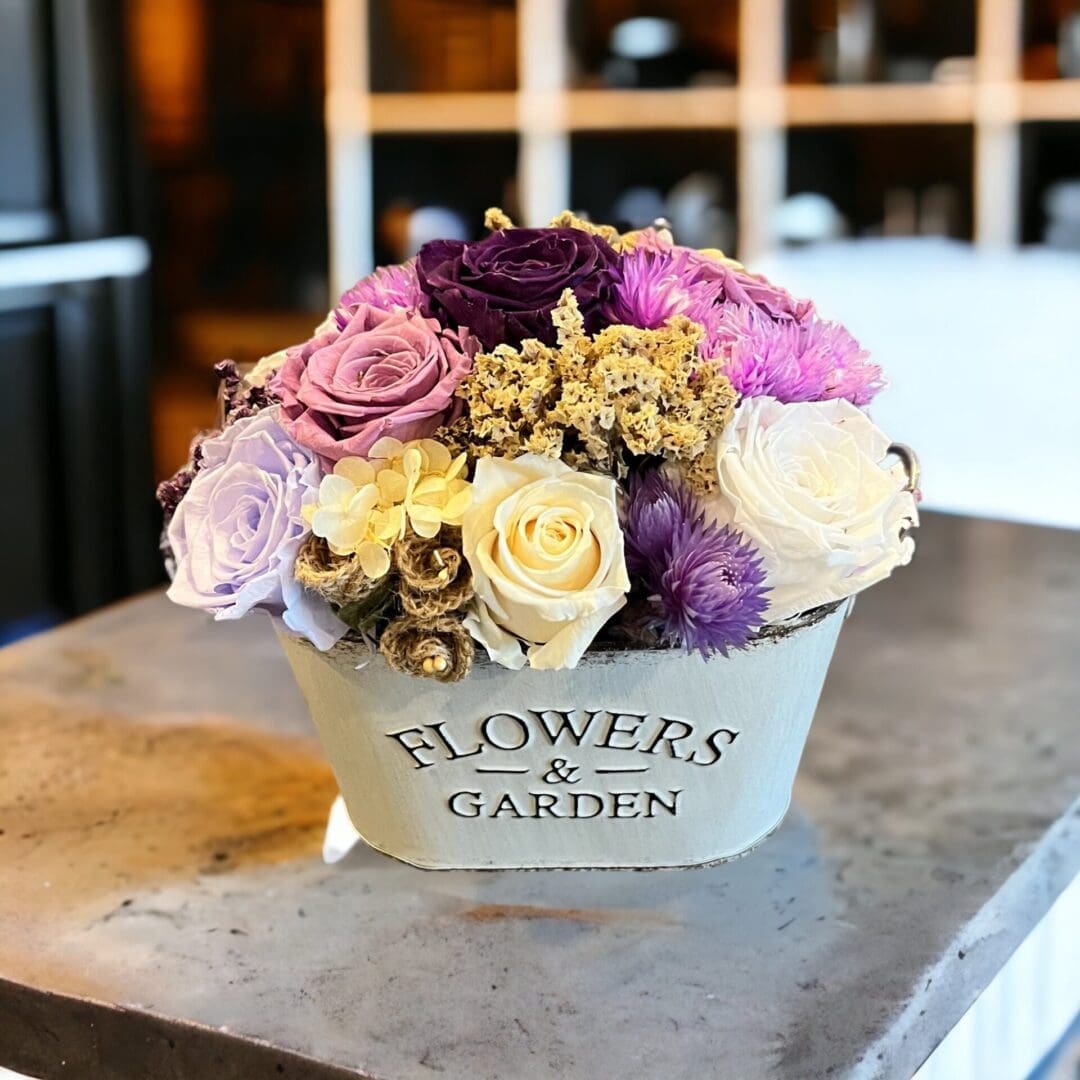A bouquet of flowers in a bowl on top of a table.