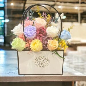 A bouquet of flowers in a box on top of a table.