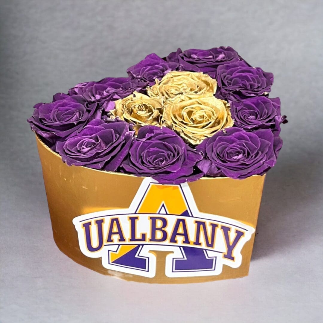 A heart shaped box with purple and yellow roses.