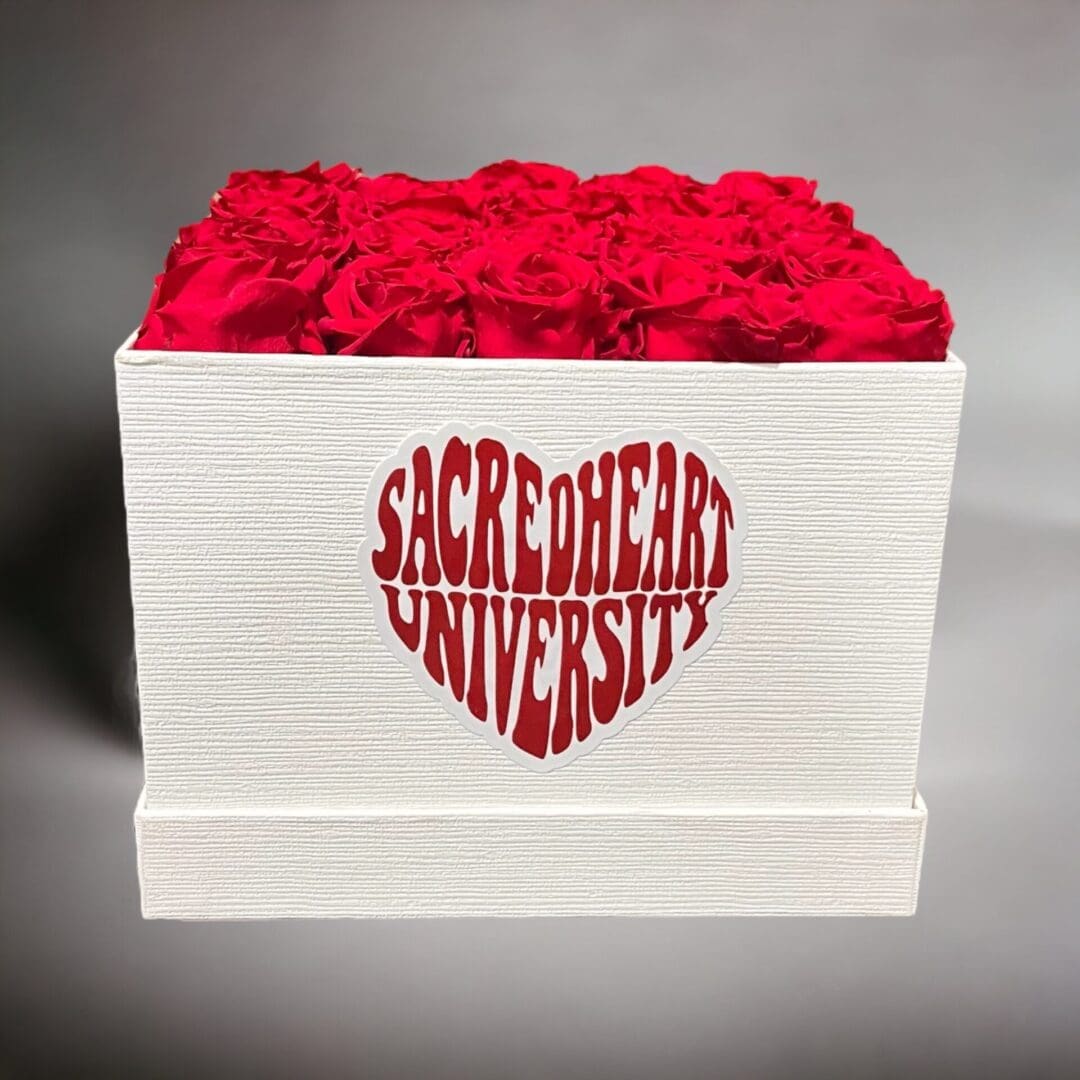 A white box with red roses inside of it.