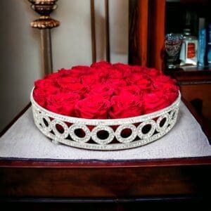A bowl of red roses on top of a table.