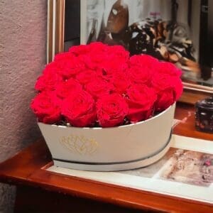 A white hat box filled with red roses.