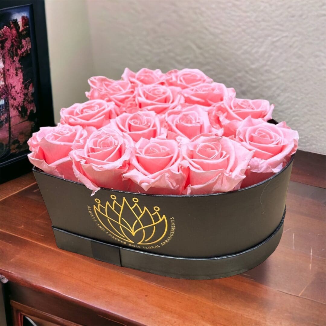A box of pink roses on top of a table.