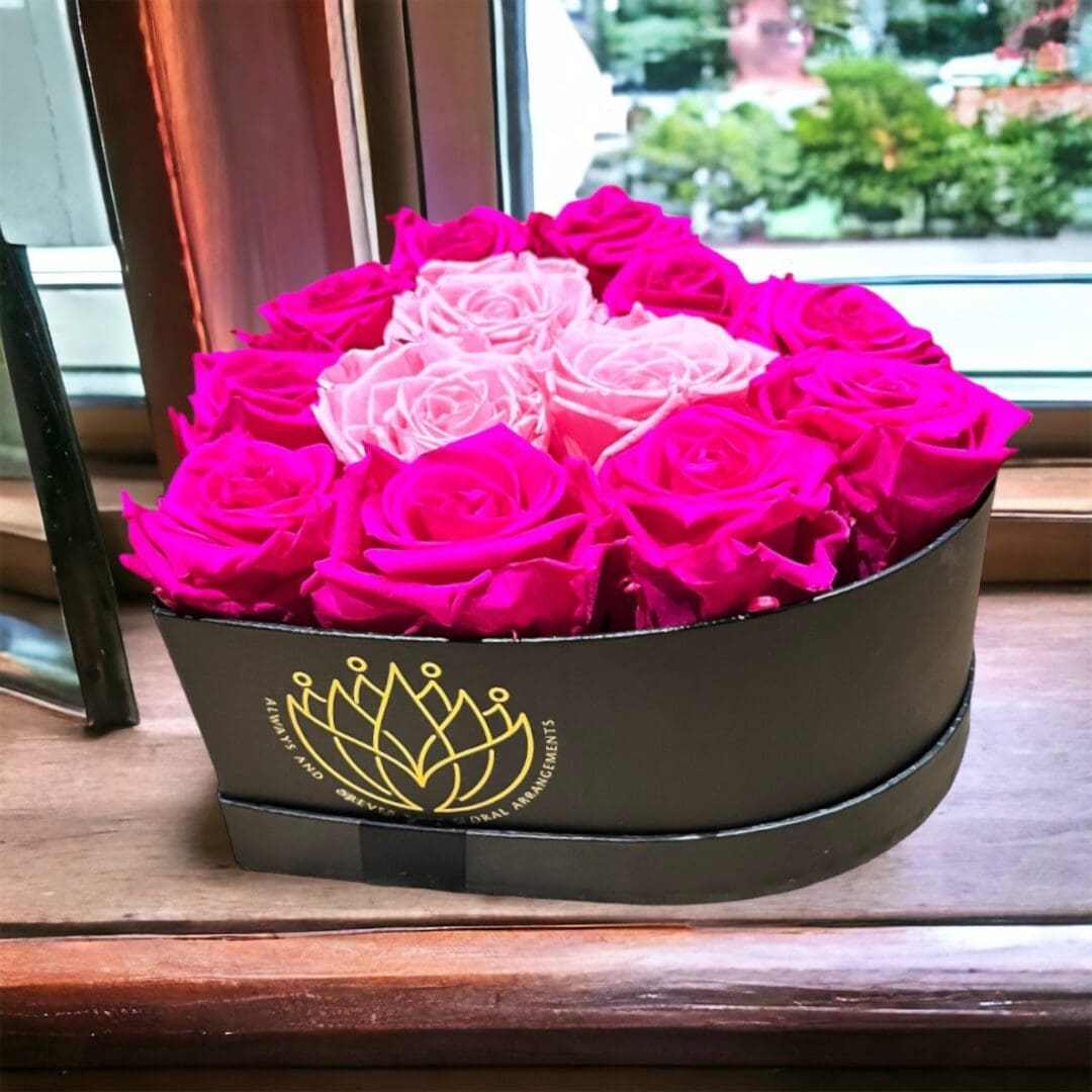 A box of roses sitting on top of a window sill.