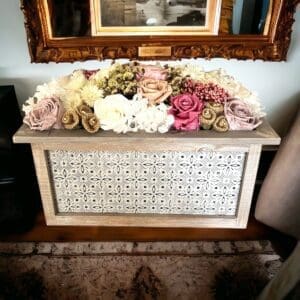 A wooden box with flowers in it on the floor.