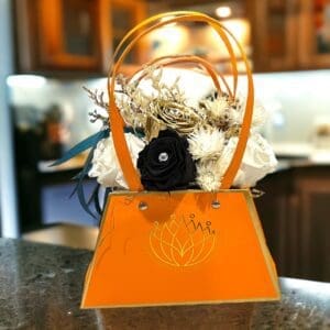 A small orange purse with flowers in it.
