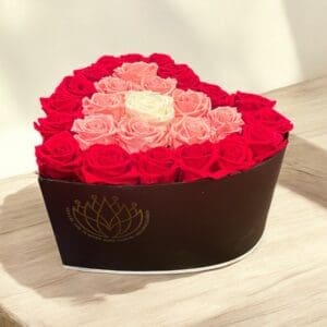 A heart shaped box of roses on top of a table.